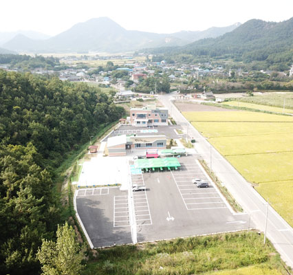 상공에서 바라본 탐진사인마을 전경으로 논밭과 푸른 산이 있는 모습